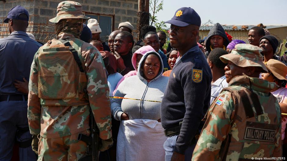 South African police and military personnel gather at a scene following mass shootings that left at least 27 dead.
