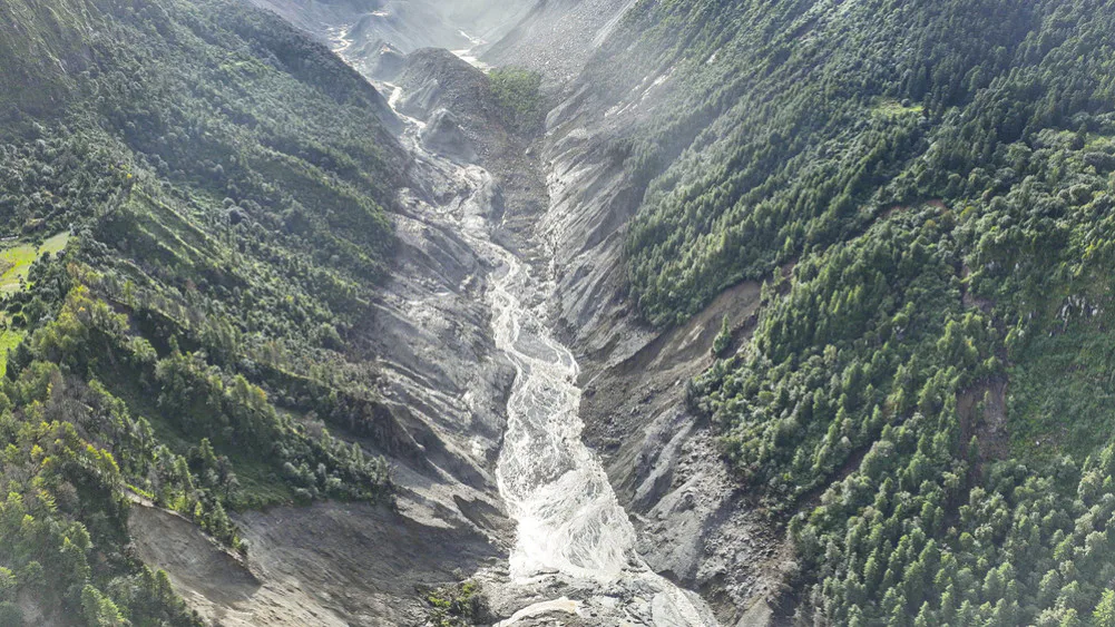 An aerial view shows a Himalayan valley affected by flooding, highlighting the risks prompting Nepal's glacial lake drainage project.